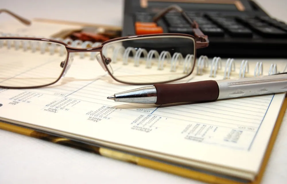 Desk with a planner, glasses and a calculator