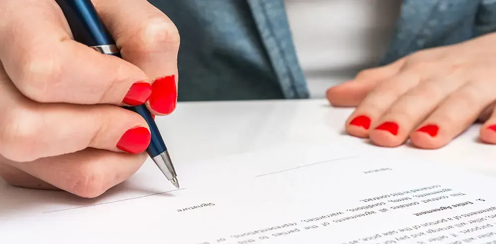Person signing a business contract with a pen