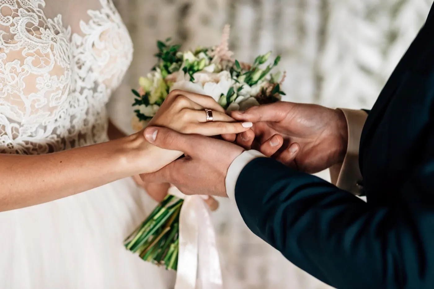 Groom placing a wedding ring on the bride's finger