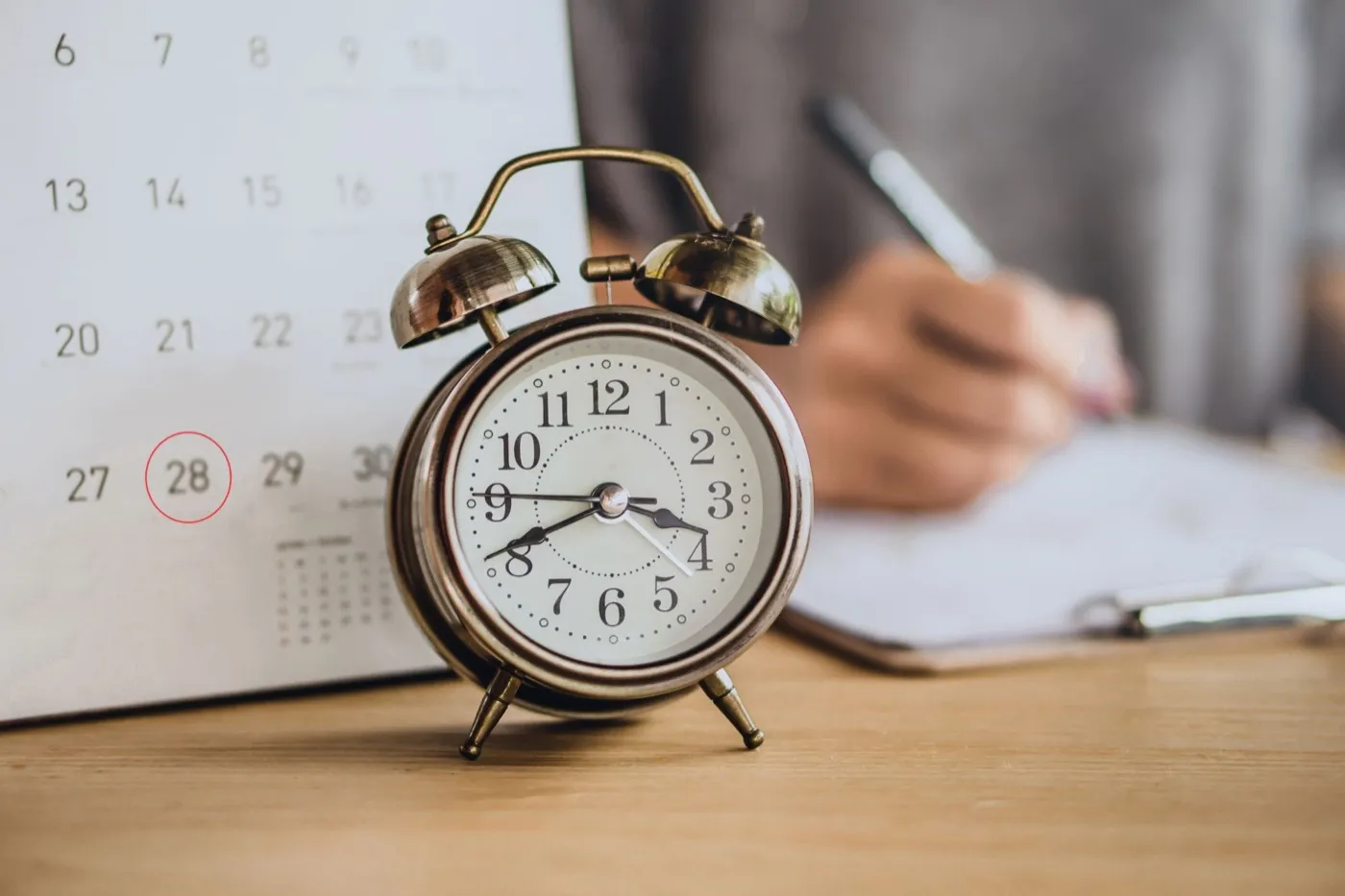 Alarm clock beside a calendar with a date circled
