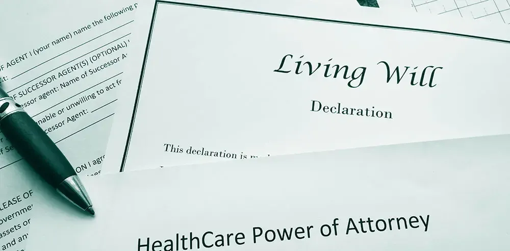 Living will declaration and healthcare power of attorney forms on a desk