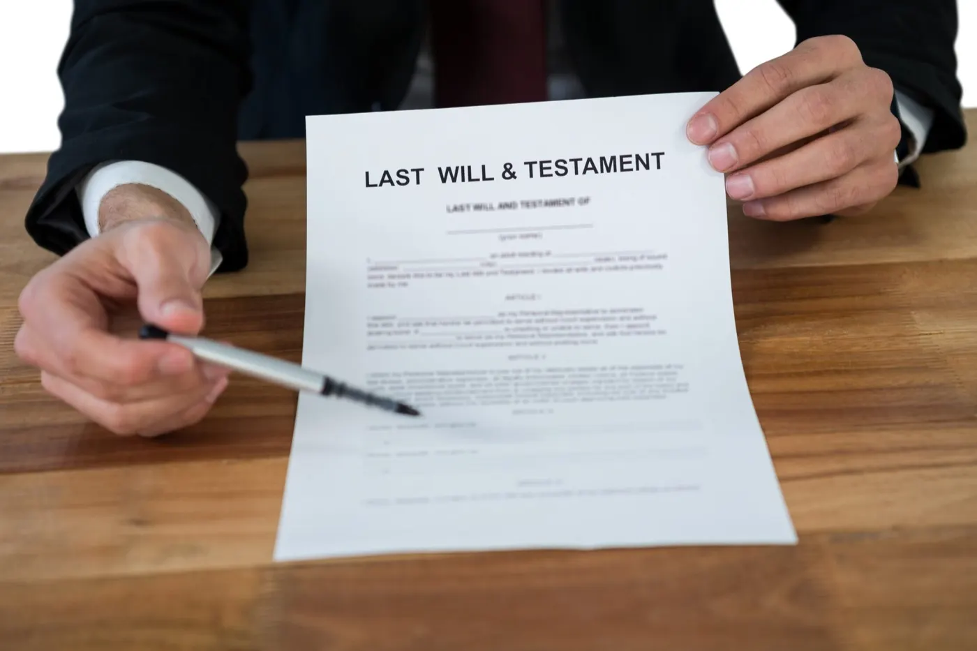 Attorney pointing to a last will and testament on a desk